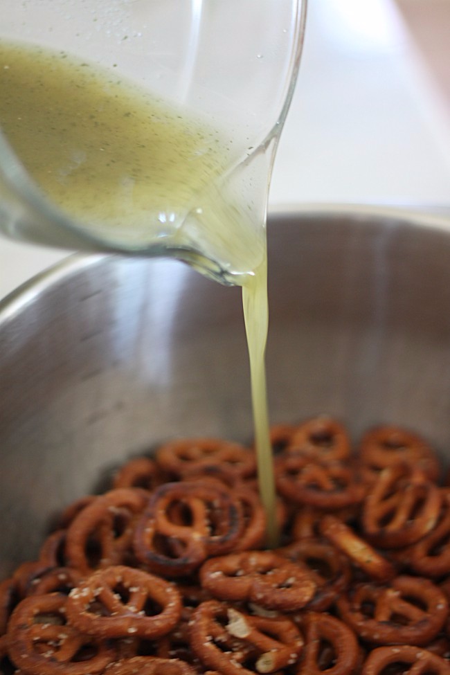 Pouring Coconut Oil and Garlic Flavoring over pretzels